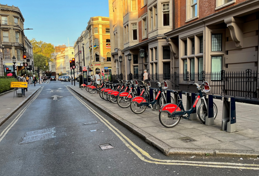 Santander bike docking station with bikes parked on an area of widened pavement