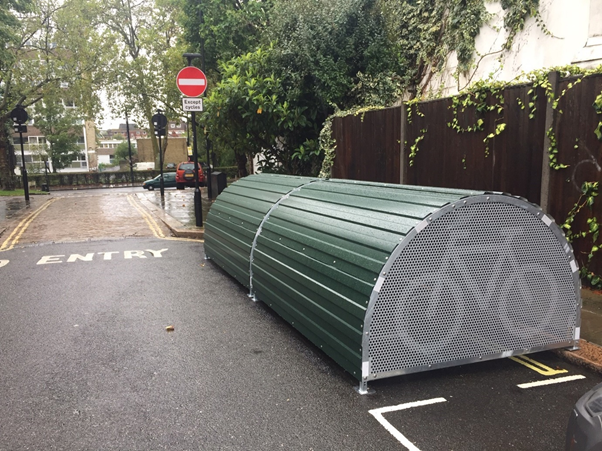 Bike hangar - a green curved metal structure with a cycle logo printed on the side