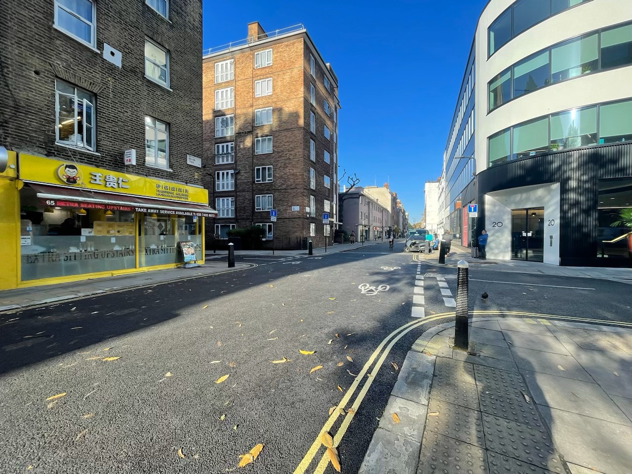 Image of Red Lion Street with a yellow shop on one side and a person cycling through the area