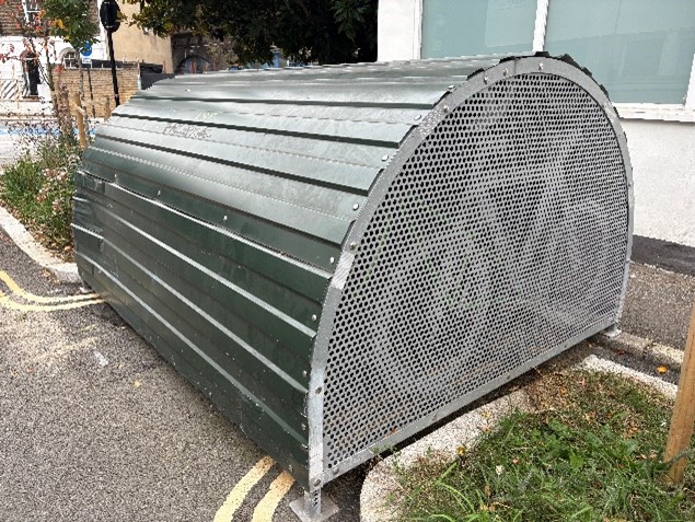 Green cycle hangar made of metal with a bike logo on the side